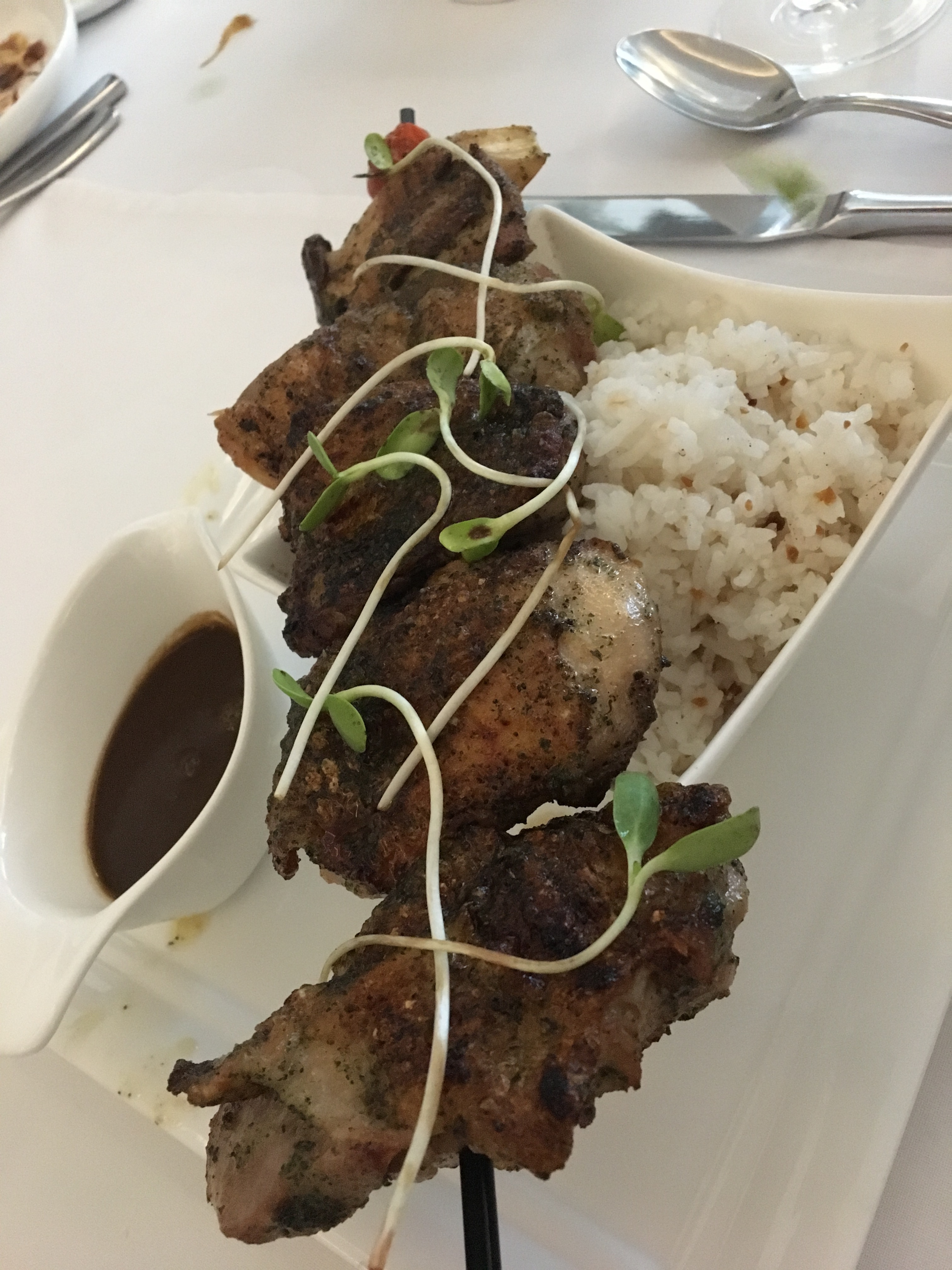 Boneless grilled chicken chunks on a skewer with rice